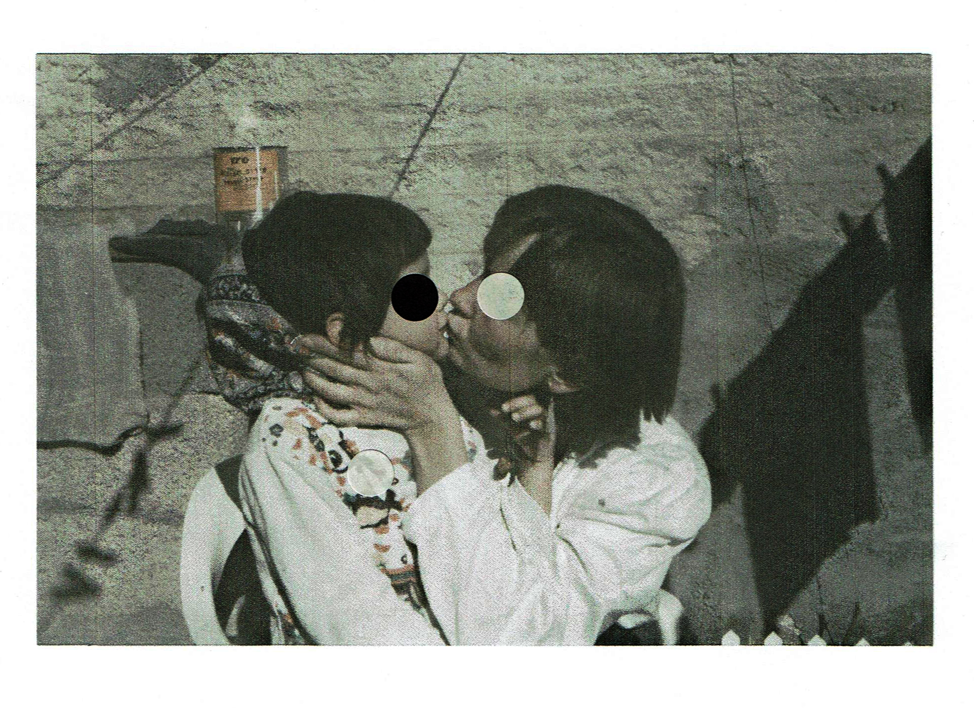 a parent kisses a child. the photo is decorated with paper circles